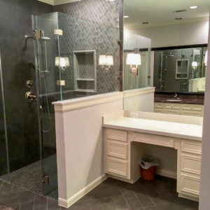 A bathroom shower stall next to the vanity